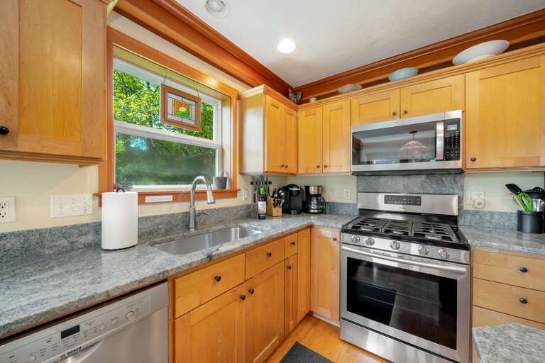Fully equipped kitchen with gas stove, large fridge and drip pot and pod coffee maker. 