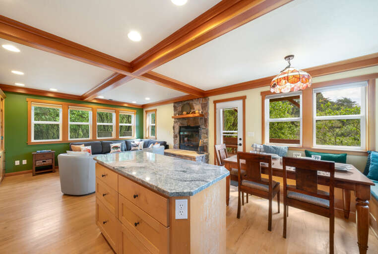 Dining area with bench seating. Fully equipped kitchen, access to outside deck and hot tub. 