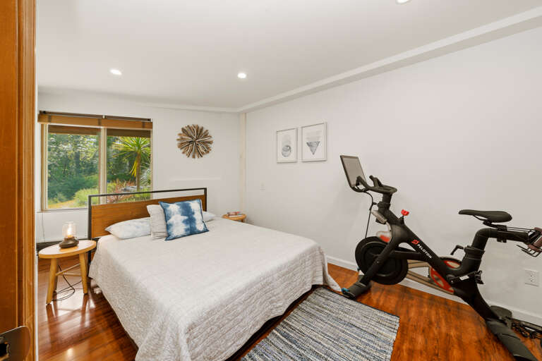 Downstairs queen bed with peleton bike. 