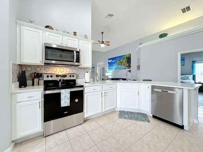 - Fully equipped kitchen featuring stainless steel appliances and crisp white cabinets
- Hexagonal backsplash and beachy accents add a touch of playful elegance
- Open concept layout makes it easy to cook and stay connected with the group - Fully equipped kitchen featuring stainless steel appliances and crisp white cabinets
- Hexagonal backsplash and beachy accents add a touch of playful elegance
- Open concept layout makes it easy to cook and stay connected with the group