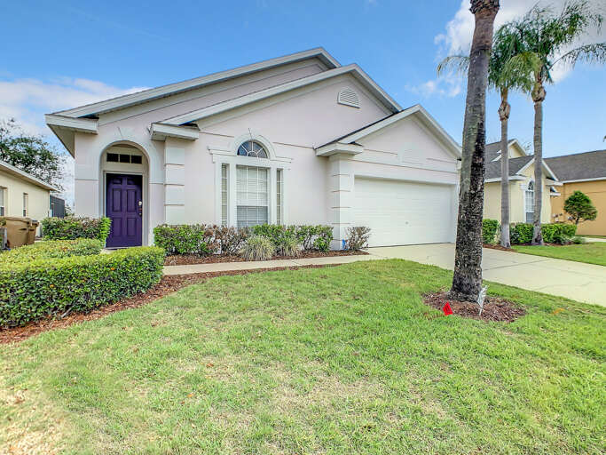 Charming pastel home with a bold purple door, manicured lawn, and spacious driveway. Charming pastel home with a bold purple door, manicured lawn, and spacious driveway.