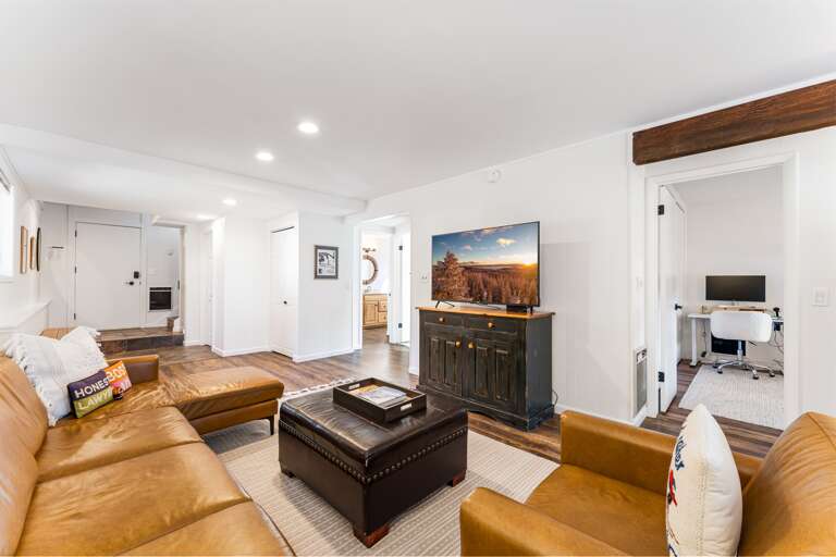 First Floor Living Room - Setup with a gas fireplace, access to the ping pong on the deck and a Smart TV.