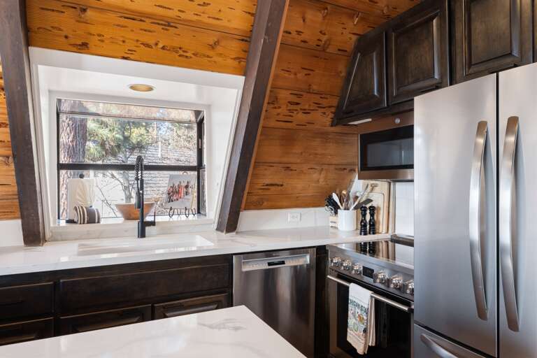 A chef's delight! The gourmet kitchen features sleek countertops, state-of-the-art appliances, perfect for meal prep or casual dining. Seating for 4 around the kitchen. A drip coffee maker is provided.