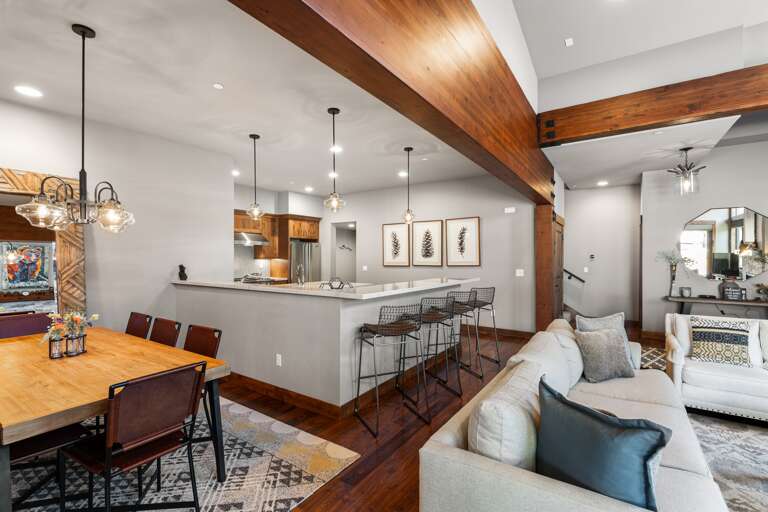 Relax in the inviting great room, where soaring ceilings and large windows flood the space with natural light. Cozy up by the stone fireplace and enjoy the 55" Smart TV. Relax in the inviting great room, where soaring ceilings and large windows flood the space with natural light. Cozy up by the stone fireplace and enjoy the 55" Smart TV.