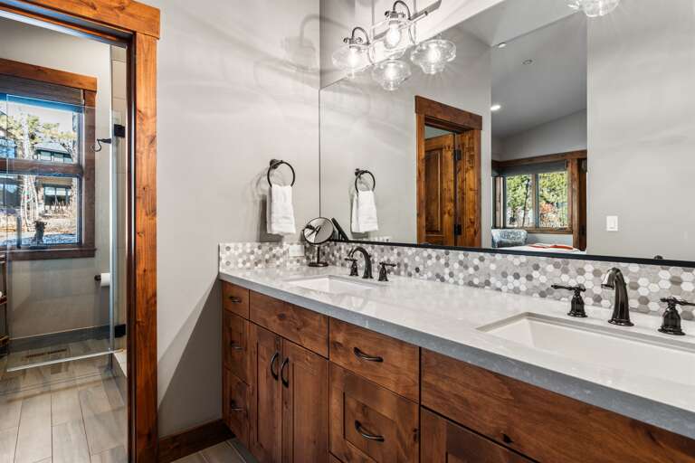 The spa-like primary bathroom features dual vanities and a walk-in shower, creating a serene space for relaxation. Essentials such as toilet paper, hand soap, shampoo, conditioner, and body wash are provided for your convenience.