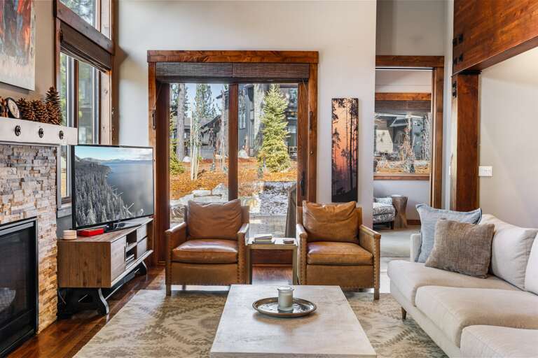 Relax in the inviting great room, where soaring ceilings and large windows flood the space with natural light. Cozy up by the stone fireplace and enjoy the 55" Smart TV.