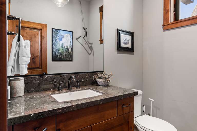 Located on the first floor, this half bathroom features a single vanity and is thoughtfully stocked with ample hand soap and toilet paper for a comfortable stay.