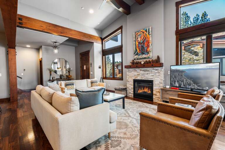 Relax in the inviting great room, where soaring ceilings and large windows flood the space with natural light. Cozy up by the stone fireplace and enjoy the 55