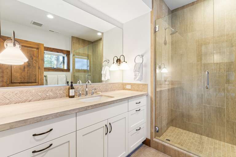 This bathroom features a single vanity and a spacious walk-in shower, providing both style and functionality. Thoughtfully stocked with shampoo, conditioner, and body wash for a comfortable stay. This bathroom features a single vanity and a spacious walk-in shower, providing both style and functionality. Thoughtfully stocked with shampoo, conditioner, and body wash for a comfortable stay.