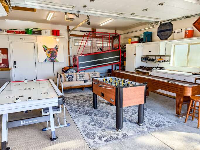 The garage has been transformed into a fun-filled game room featuring Hoop Fever, shuffleboard, air hockey, and foosball. Plus, it's fully heated for year-round enjoyment. In the summer, open up the garage and enjoy the fresh air!