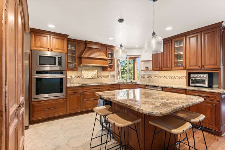 This cozy kitchen features sleek countertops, state-of-the-art appliances, and an island perfect for meal prep or casual dining, with seating for four. Whether you're cooking breakfast or pouring a glass of wine, it’s the heart of the Highland A-frame.