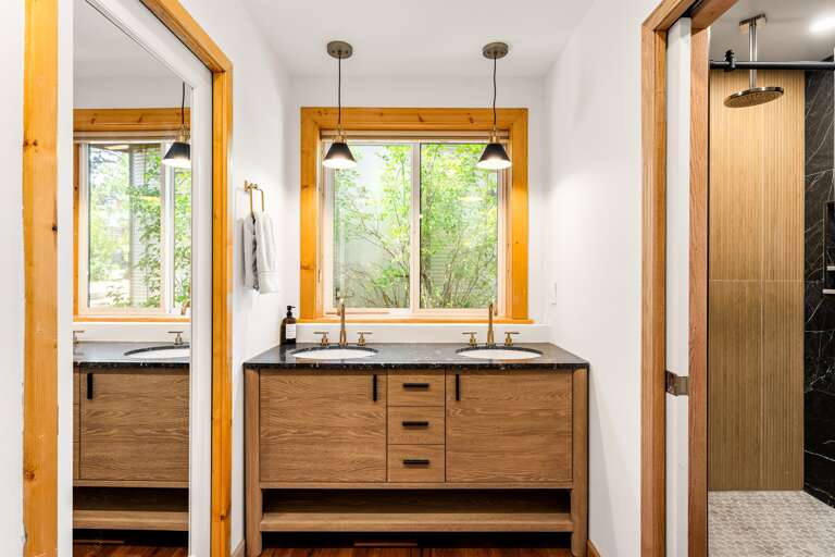 Rest easy in the spacious primary bedroom with a king bed, twin bed with trundle, a 55" Smart TV, and an en-suite bathroom featuring a walk-in shower and dual vanities for your convenience.