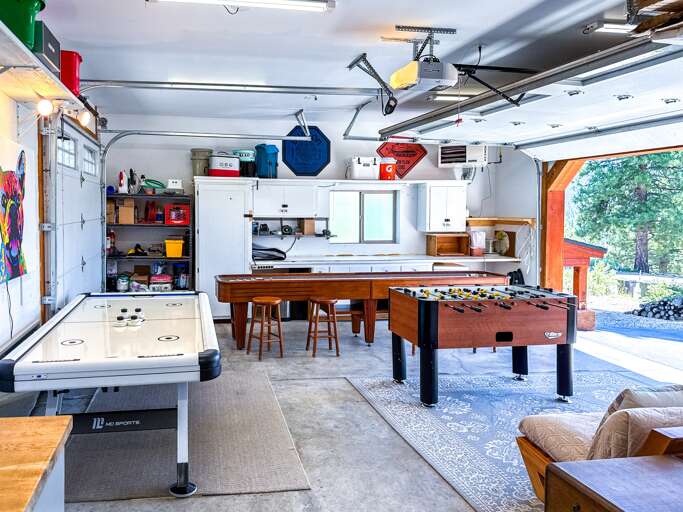 The garage has been transformed into a fun-filled game room featuring shuffleboard, air hockey, and foosball — and it's fully heated for year-round enjoyment. In the summer, open up the garage