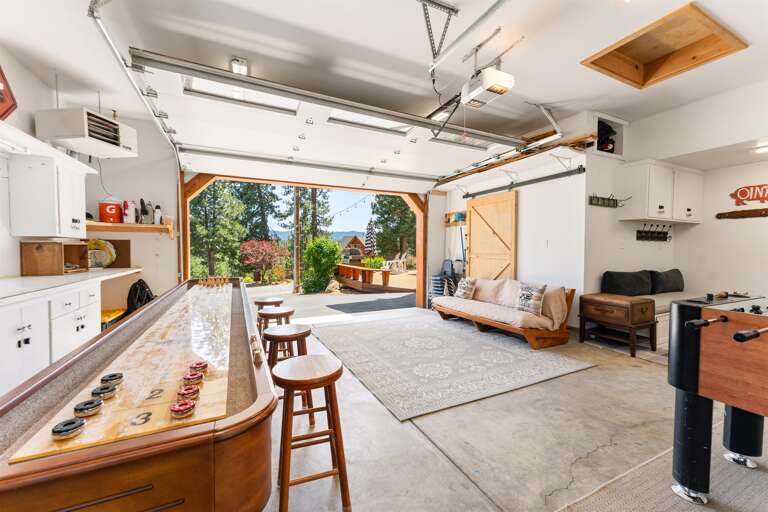 The garage has been transformed into a fun-filled game room featuring shuffleboard, air hockey, and foosball — and it's fully heated for year-round enjoyment. In the summer, open up the garage door for fresh air and indoor-outdoor vibes!