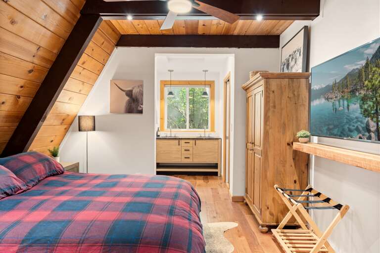 Rest easy in the spacious primary bedroom with a king bed, twin bed with trundle, a 55" Smart TV, and an en-suite bathroom featuring a walk-in shower and dual vanities for your convenience.