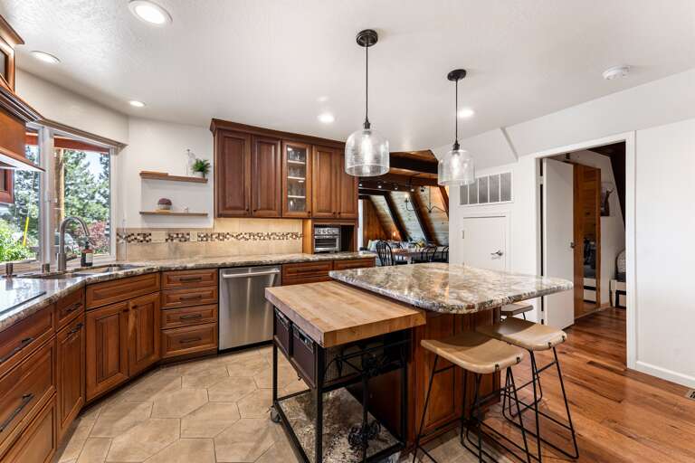 This cozy kitchen features sleek countertops, state-of-the-art appliances, and an island perfect for meal prep or casual dining, with seating for four. Whether you're cooking breakfast or pouring a glass of wine, it’s the heart of the Highland A-frame.
