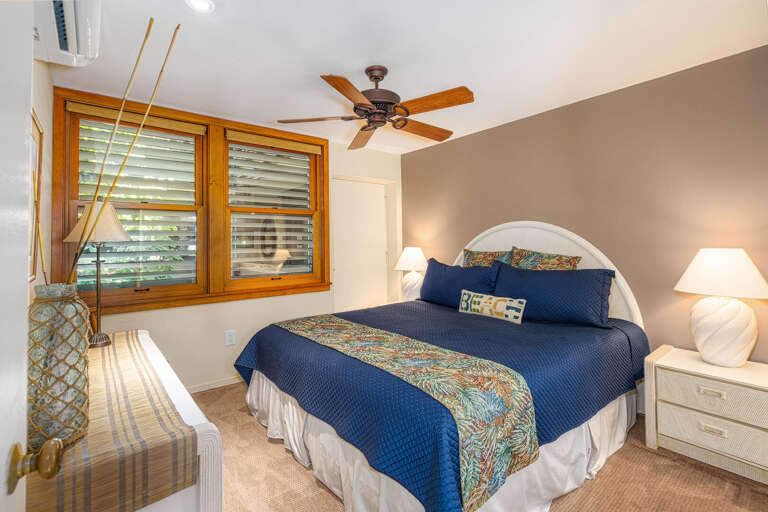 Interior Of A Bedroom With Blue Bedding And Wooden Blinds