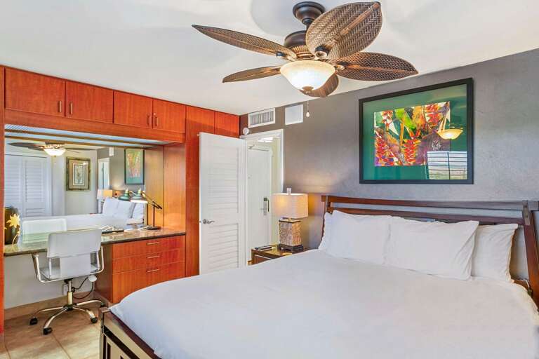 Interior Of Vacation Rental Bedroom With Ceiling Fan And Attached Bathroom
