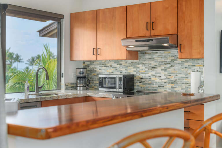 Kitchen Interior In Vacation Rental With Wooden Cabinets And Ocean View