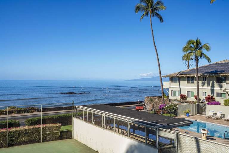 Seaside Structure Surrounded By Sand, Sea, And Swaying Palms