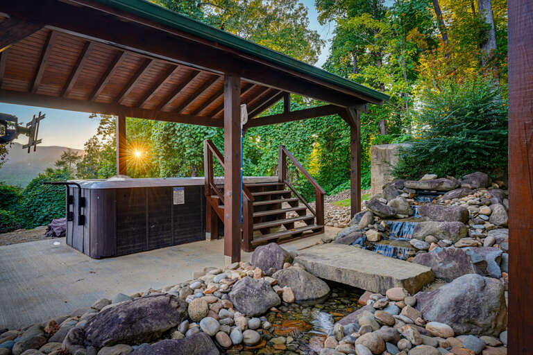 Relax in the covered swim spa by your private waterfall