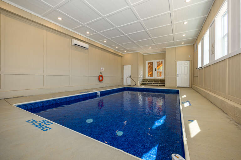 Indoor Pool Under Luminous Lights With A Reflective Blue Surface