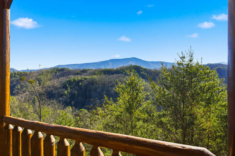 Deck View With Distant Mountains And Lush Greenery