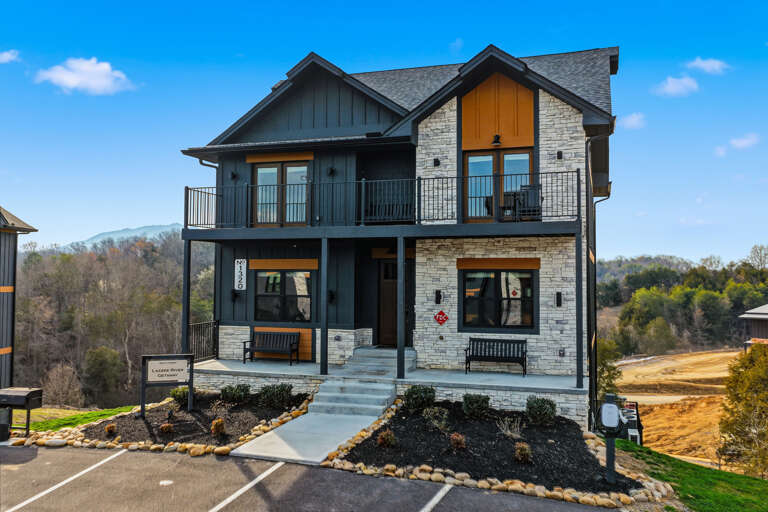 Two-story Stone And Wood Vacation Rental With Balconies And Surrounding Greenery