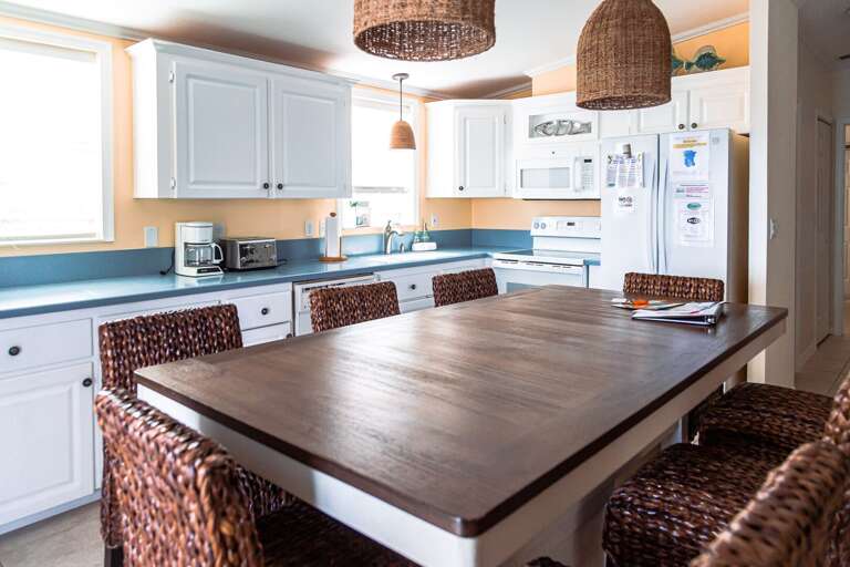 Vacation Rental Kitchen With Wicker Chairs And Wooden Table