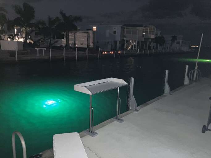 Nighttime Dock Scene With Green Glowing Underwater Light