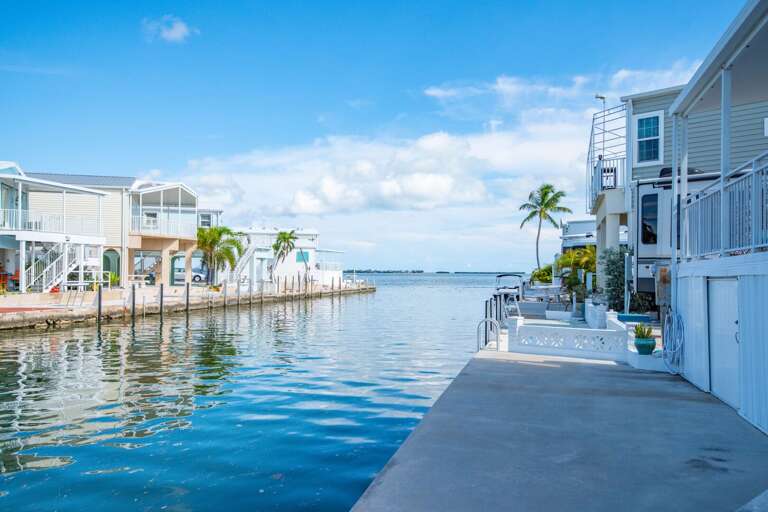 Waterfront Walkway By White Vacation Rental Buildings Under Blue Skies