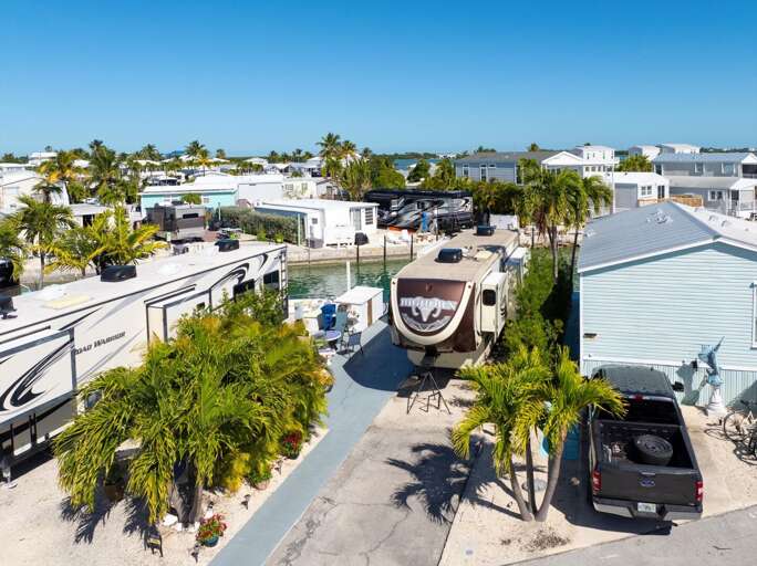 Aerial View Of Sunny Suburban Setting With Trees And Trailers