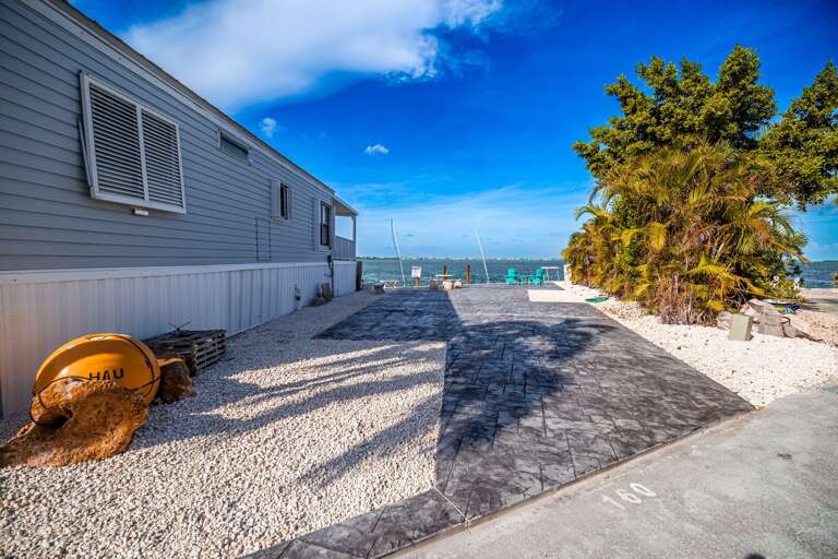 Seaside Structure Shrouded In Sunshine, With A Sprawling Stone Surface And Solitary Shrub