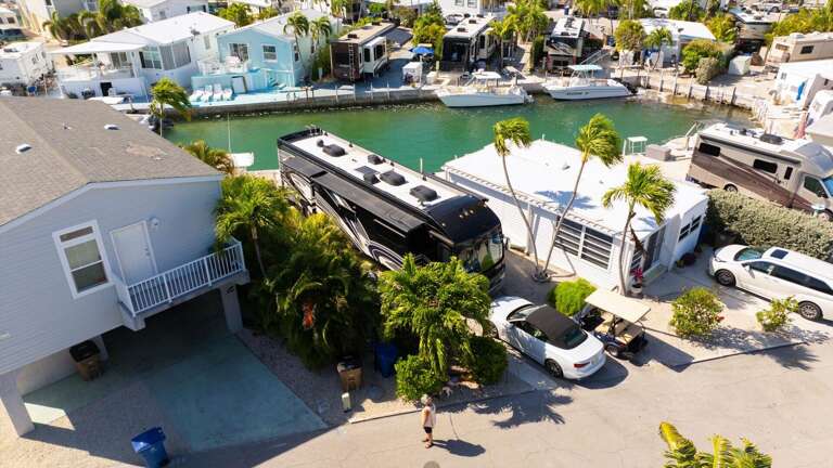 Aerial View Of A Bustling Bayside Block, Boats Berthed Beside Buildings