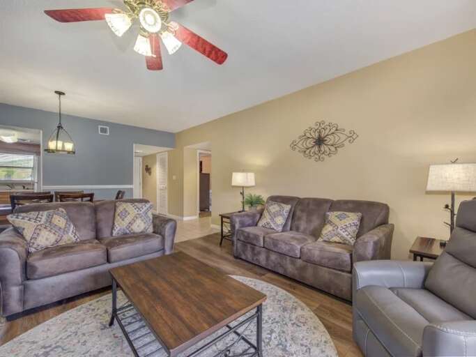 Spacious Sitting Area With Sofas And Central Table Under A Ceiling Fan Spacious Sitting Area With Sofas And Central Table Under A Ceiling Fan