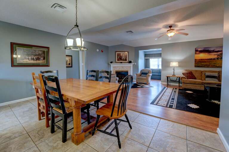 Interior View Featuring Dining Table, Pendant Light, Fireplace, And Ceiling Fan
