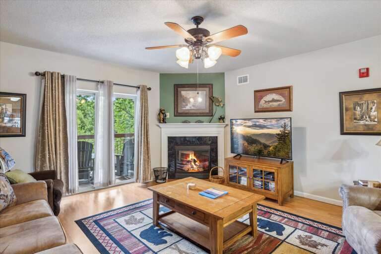 Living Room With Ceiling Fan, Fireplace, And Balcony Access Living Room With Ceiling Fan, Fireplace, And Balcony Access