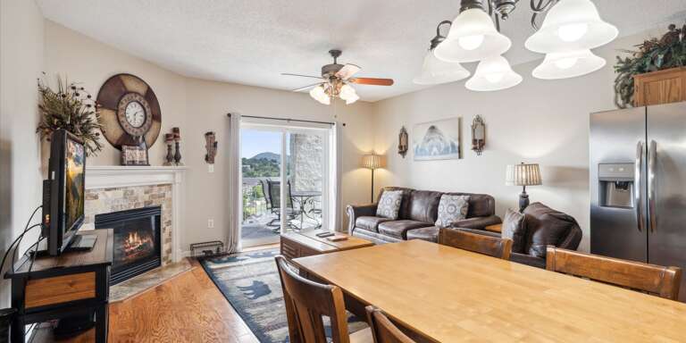 Spacious Living Space With Sleek Steel Appliances, Fireplace, And Flow To Outdoor Patio