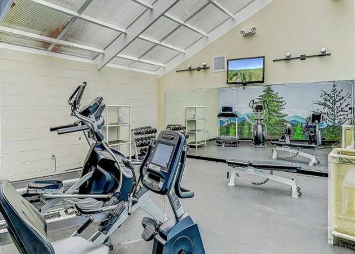 Fitness Facility Featuring Machines, Mirrors, And Mounted Monitors