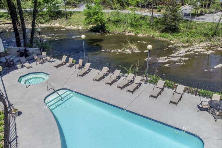 Poolside Patio By Placid River, Lounge Chairs Lined Leisurely Poolside Patio By Placid River, Lounge Chairs Lined Leisurely