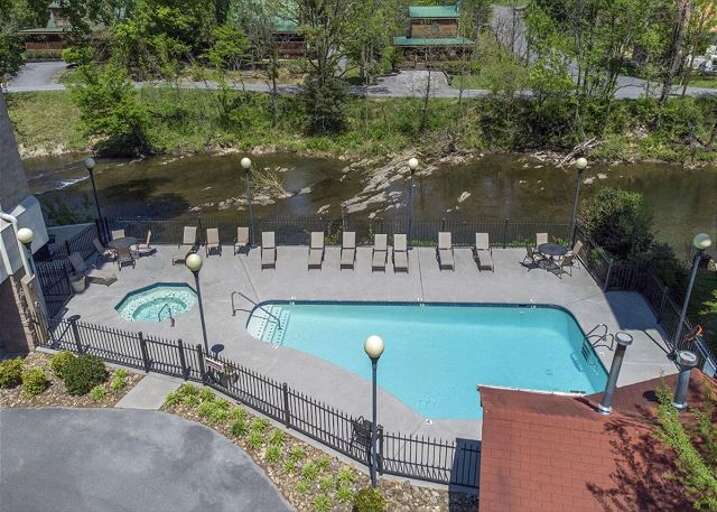 Poolside Loungers Lined Beside Rippling River Poolside Loungers Lined Beside Rippling River