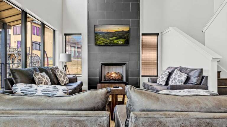 Main entry (middle level) living room, with modern, open kitchen, dining and living room. Living Room features gas fireplace, large SMART TV, and Wifi