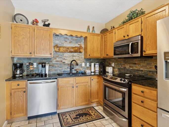 Kitchen Space In A Vacation Rental, Featuring Stainless Steel Appliances And Wooden Cabinets