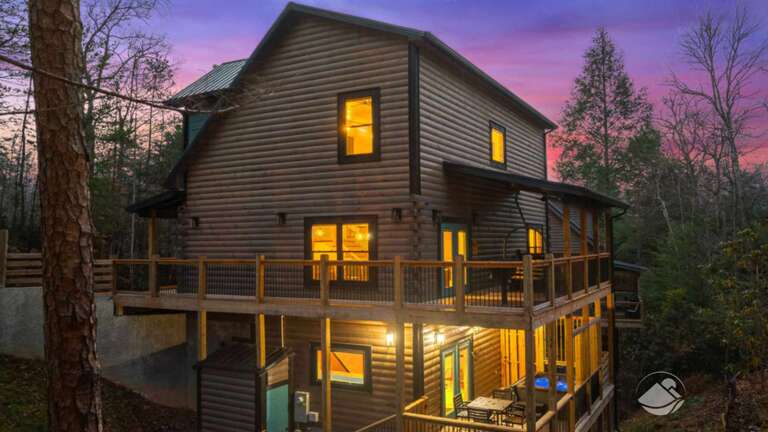 Wooden Building With Lit Windows At Dusk, Nestled Among Nature