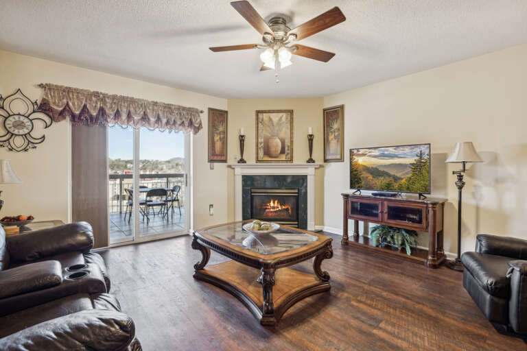 Living Room With Leather Loungers, Wooden Table, And Flickering Fireplace