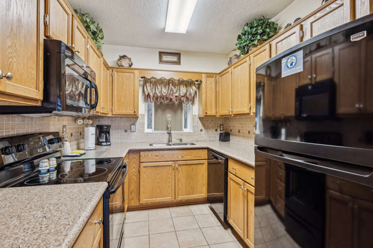 Spacious Kitchen With Sleek Stainless Steel Appliances And Light-colored Cabinets, Complemented By Clean Countertops And Bright Backsplash