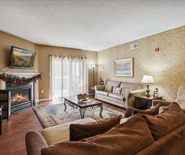 Spacious Living Room With Sofa, Fireplace, And Festive Decorations Spacious Living Room With Sofa, Fireplace, And Festive Decorations