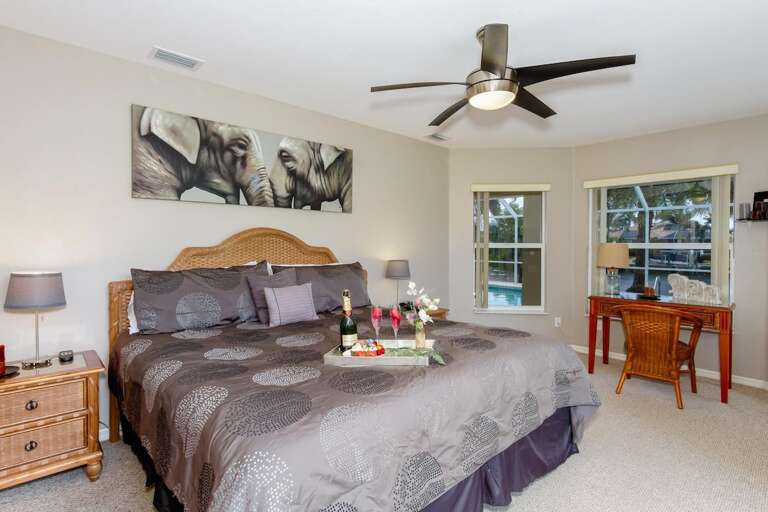 Main King Bedroom with Desk and View of the Pool and Lanai