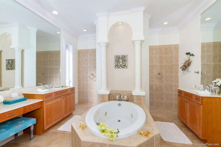 Main Bathroom with two sinks and wrap around shower as well as tub.