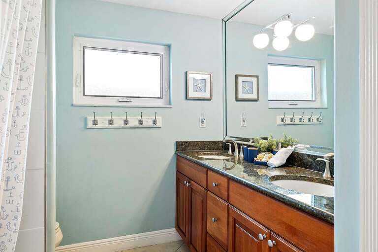 Hallway Bathroom with Dual Sinks and Shower Tub Combo